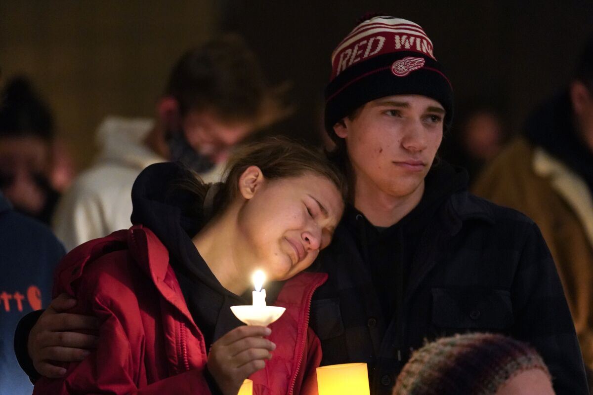 People embrace at a vigil in Oxford, Mich., after the deadly shooting at Oxford High School.