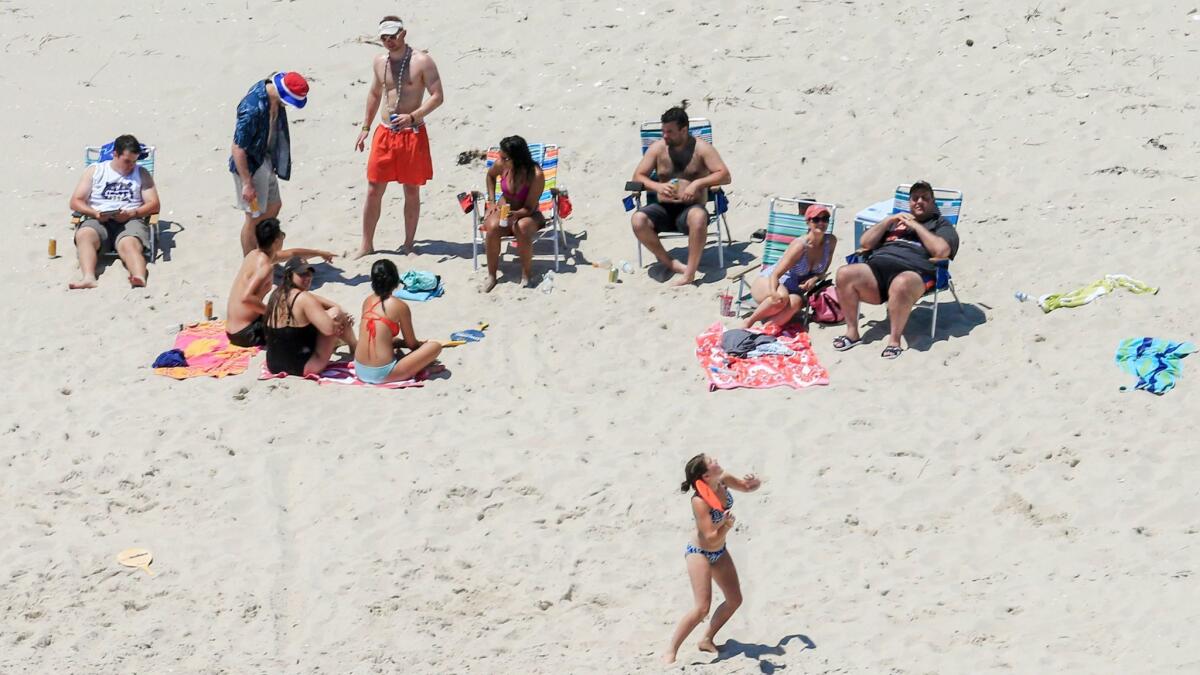 In this July 2, 2017, photo, New Jersey Gov. Chris Christie, right, uses the beach with his family and friends at the governor's summer house at Island Beach State Park.