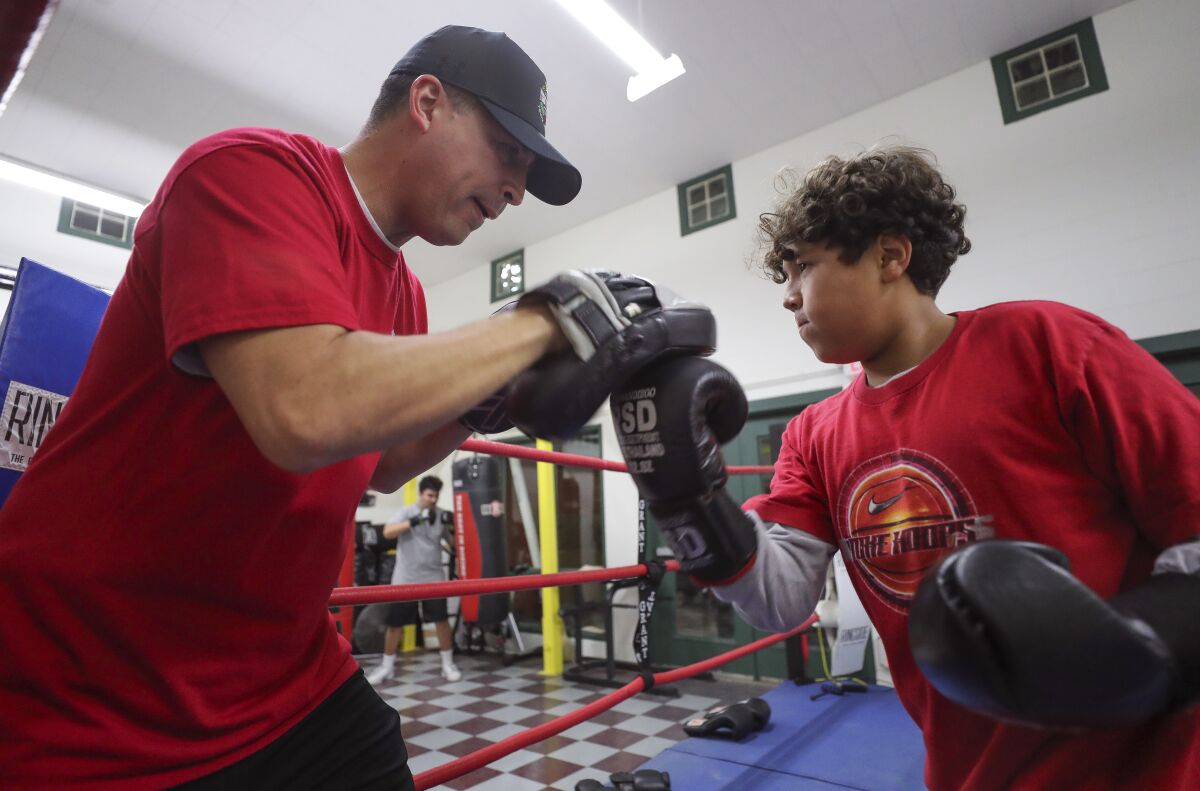 Imperial Boxing Youth Athletics Club's founder Ruben Gutierrez, a San Diego Police lieutenant, spars with Erick Villa, 12, in the boxing ring at the Dolores Magdaleno Recreation Center in Logan Heights on Thursday, December 19, 2019.