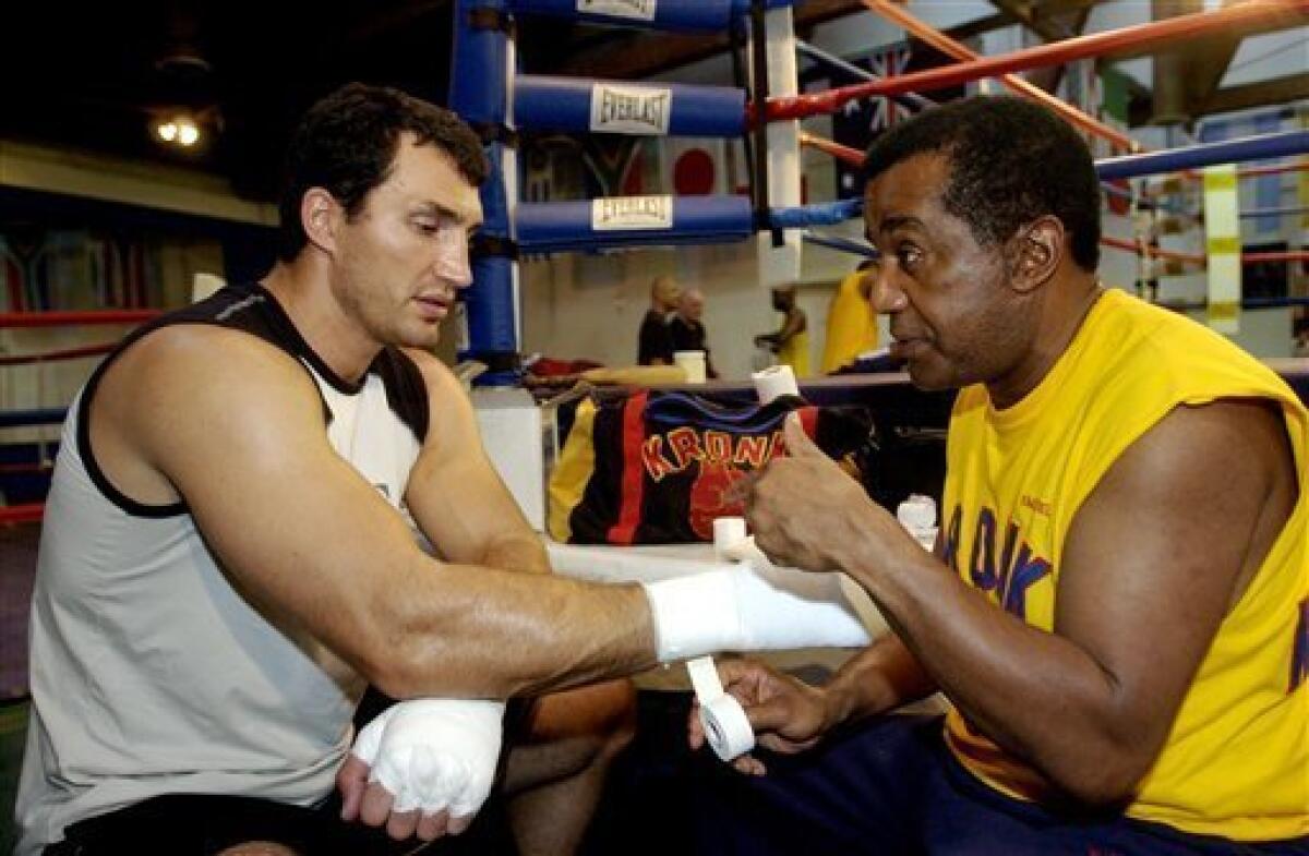 FILE- This Sept. 9, 2004 file photo shows former WBO heavyweight champion Wladimir Klitschko getting his hands taped by trainer Emanuel Steward before a workout at the La Brea Boxing Academy in Los Angeles. Steward, the owner of the legendary Kronk Gym and one of boxing's greatest trainers, has died. He was 68. Victoria Kirton, Steward's executive assistant, says Steward died Thursday Oct. 25, 2012 in a Chicago hospital. She did not disclose the cause of death. (AP Photo/Reed Saxon,File)
