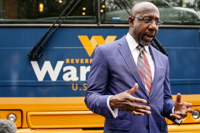 Democratic candidate for Senate Raphael G. Warnock speaks to a crowd during a "Get Out the Early Vote" event at the SluttyVegan ATL restaurant on Tuesday, Oct. 27, 2020, in Jonesboro, Ga. (AP Photo/Brynn Anderson)