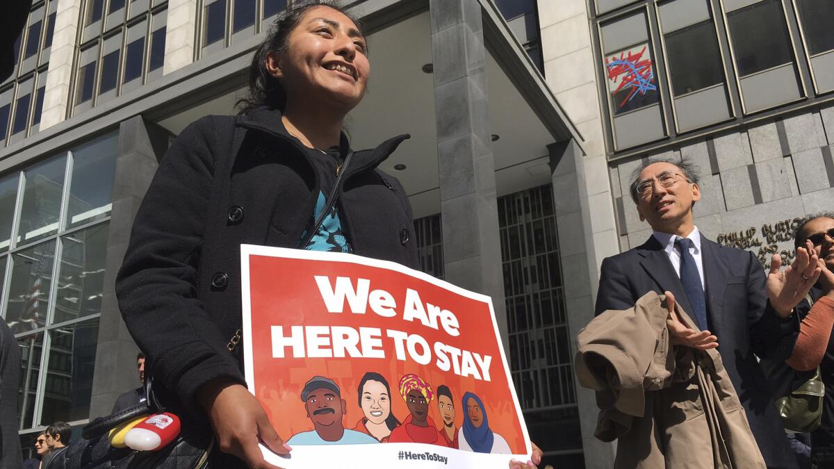 Erica Leyva with the Services, Immigrant Rights and Education Network of San Jose carries a sign outside a courthouse earlier this month when a federal judge heard arguments in the case.
