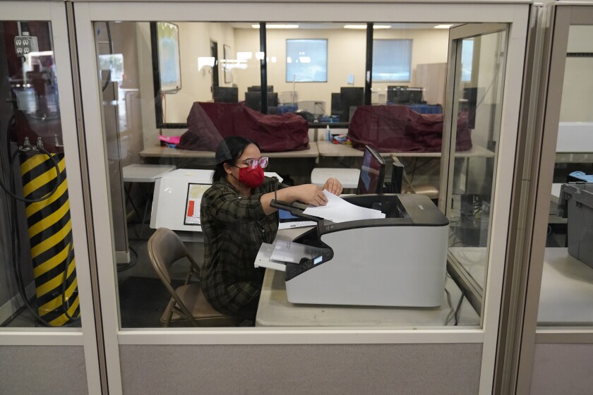 A county election worker scans ballots at a tabulating area at the Clark County Election Department in Las Vegas.