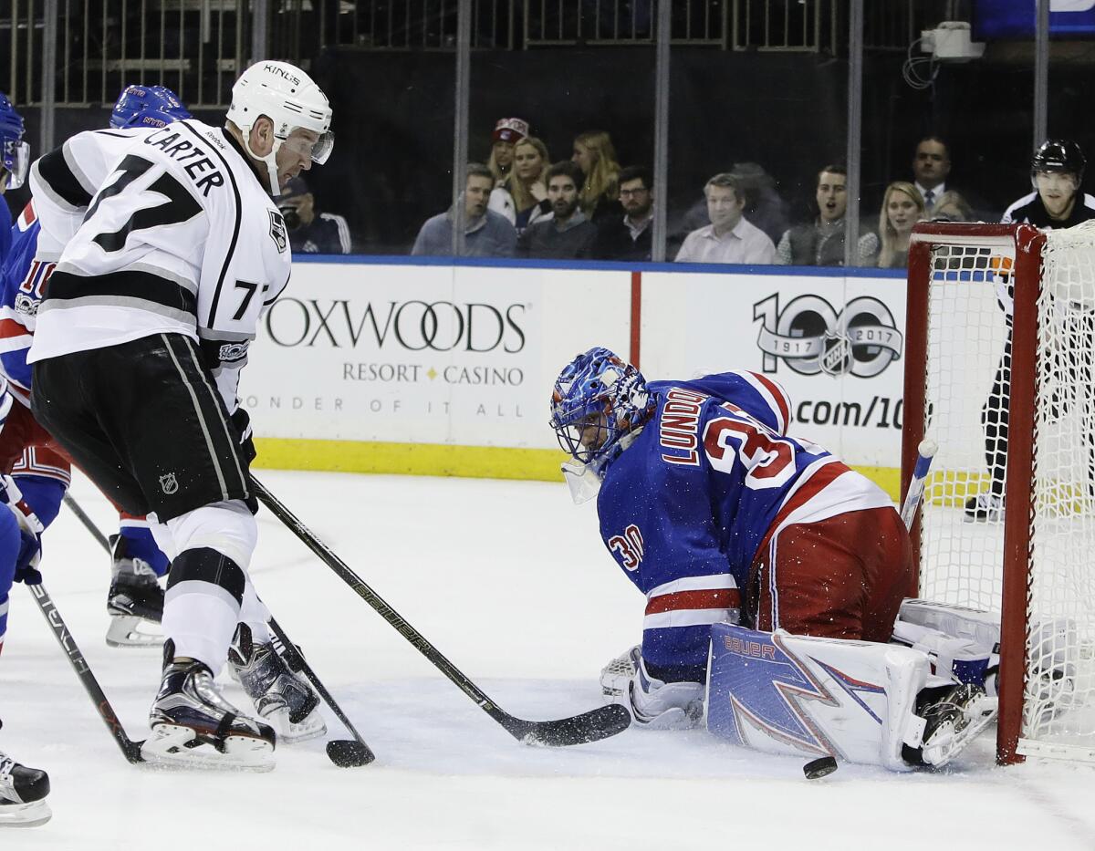 Rangers goalie Henrik Lundqvist (30) stops a shot on goal by Kings' Jeff Carter (77) during the first period Monday.