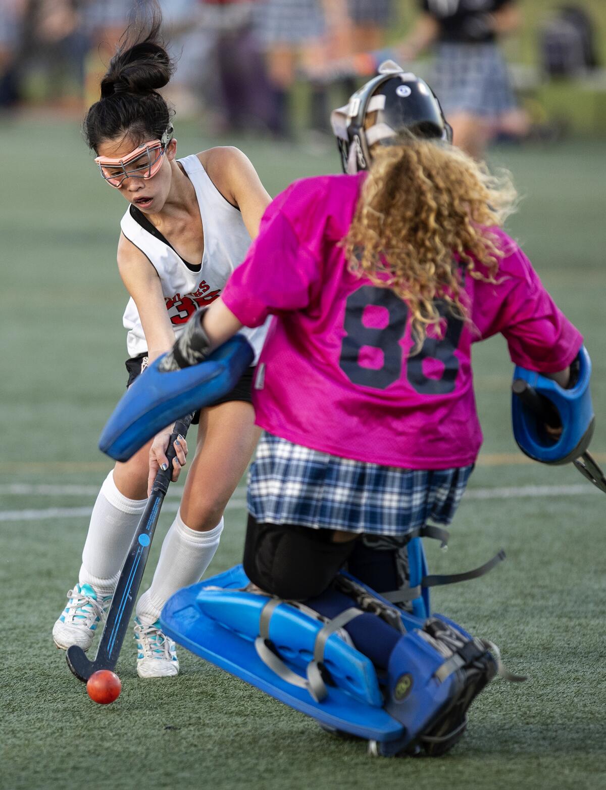 Newport Harbor's Cadence Cockrell challenges Huntington Beach's Anela Kaye during a field hockey match on Friday.