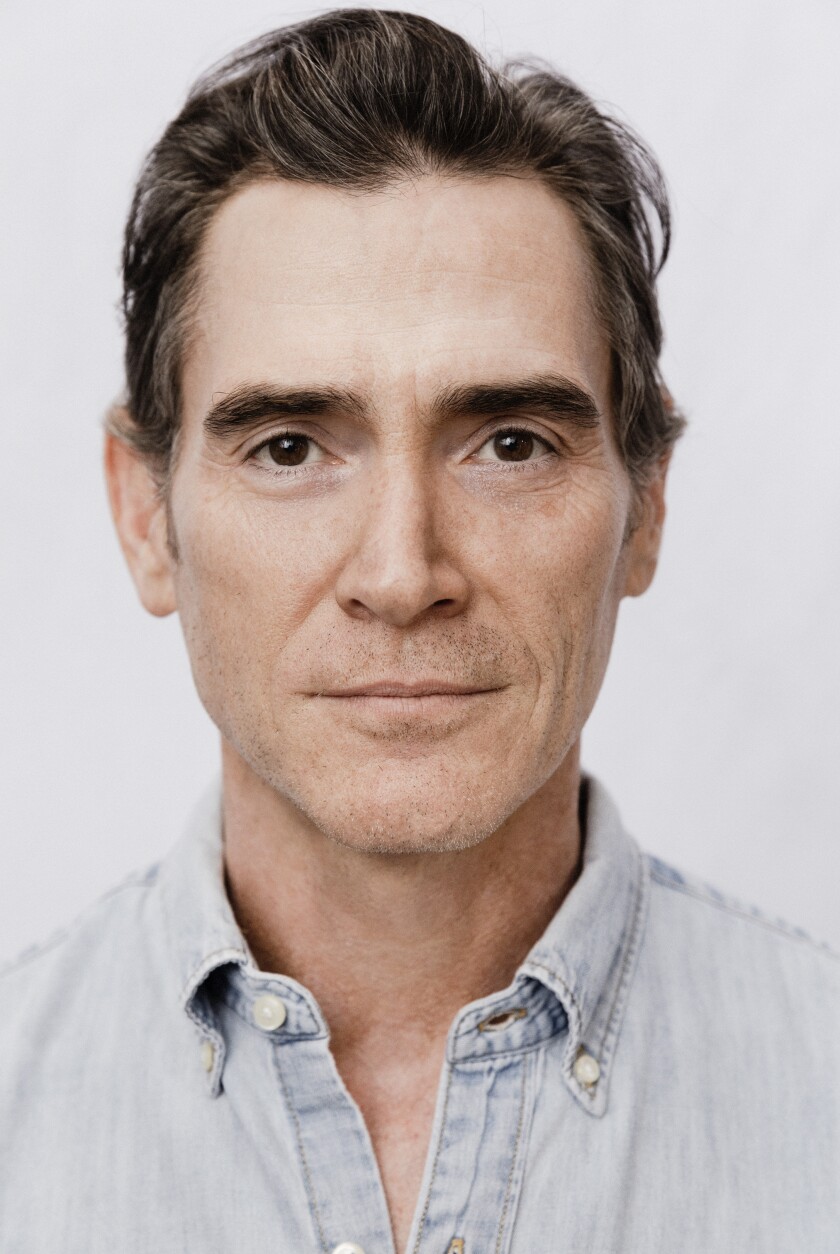 A headshot of a man in a light-blue collared shirt