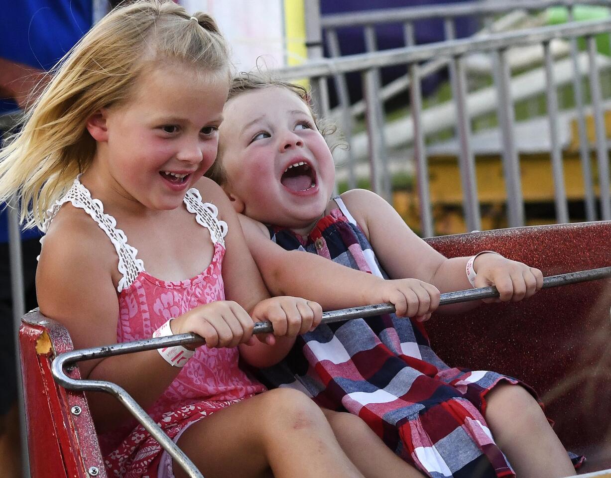 Cousins Blair Vizzini, 5, of New WIndsor, left, and Gabriella Nappier, 3, of Westminster enjoy a midway ride at the Winfield fire company carnival Wednesday, July 10, 2019.
