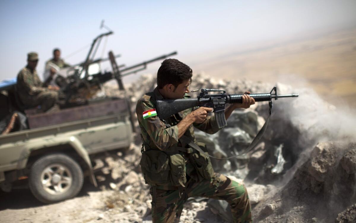 An Iraqi Kurdish peshmerga fighter fires at Islamic State militant positions from Mt. Zardak, east of Mosul.