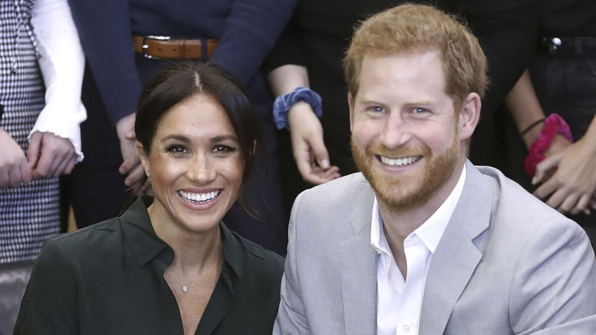 Meghan, the Duchess of Sussex, and Prince Harry pose for a photo 