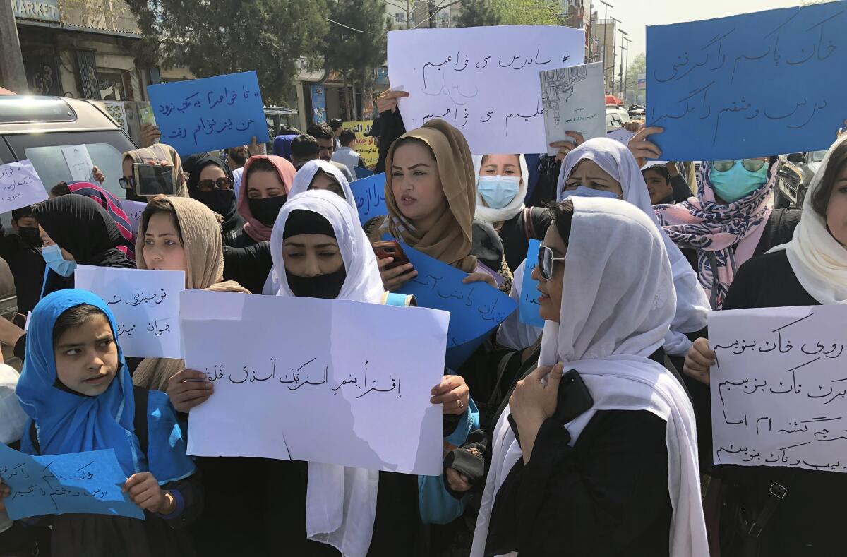 Afghan women chant and hold signs of protest during a demonstration in Kabul, Afghanistan.