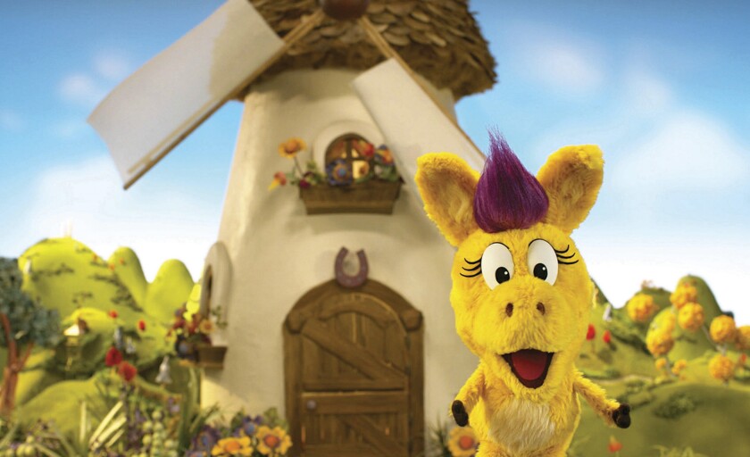This image released by PBS Kids shows the puppet Donkey Hodie from the new series, “Donkey Hodie,” inspired from characters in the original Fred Rogers TV show. The whimsical series for children ages 3-5 starts airing Monday and centers on the adventures of Donkey Hodie, an enthusiastic yellow donkey with a bright magenta mane. (Fred Rogers Productions/PBS Kids via AP)
