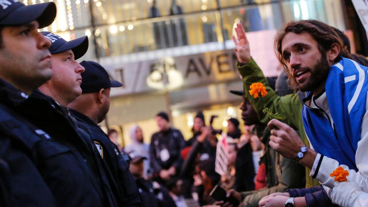 A demonstrator speaks with police officers as he protests against President-elect Donald Trump in front of Trump Tower in New York.
