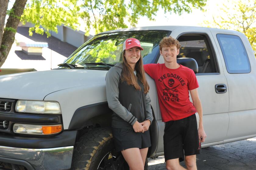 Aubrey Prunty and her boyfriend, Anthony Rist, with Rist's pickup truck. They attend Trinity High School in Weaverville and started walking to school this month because gas prices in rural California are the highest in the nation.