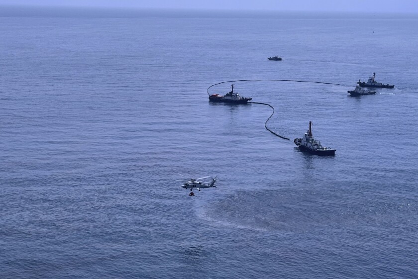 In this photo released by the Royal Thai Navy, an aerial view from a navy plane shows cleanup efforts of a large oil spill off the coast of Rayong, eastern Thailand, Thursday, Jan. 27, 2022. A special aircraft from a company specializing in recoveries from oil spills has arrived Thursday from Singapore to join an urgent effort to clean up an oil slick before it could hit beaches in eastern Thailand. (Royal Thai Navy via AP)