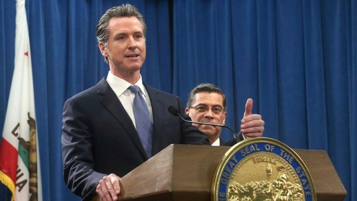 California Gov. Gavin Newsom, with Atty. Gen. Xavier Becerra, answers a question concerning a lawsuit the state plans to file against President Trump over his declaration of a national emergency at the border.