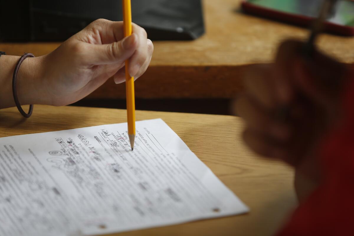 Hand grips a pencil over a written test