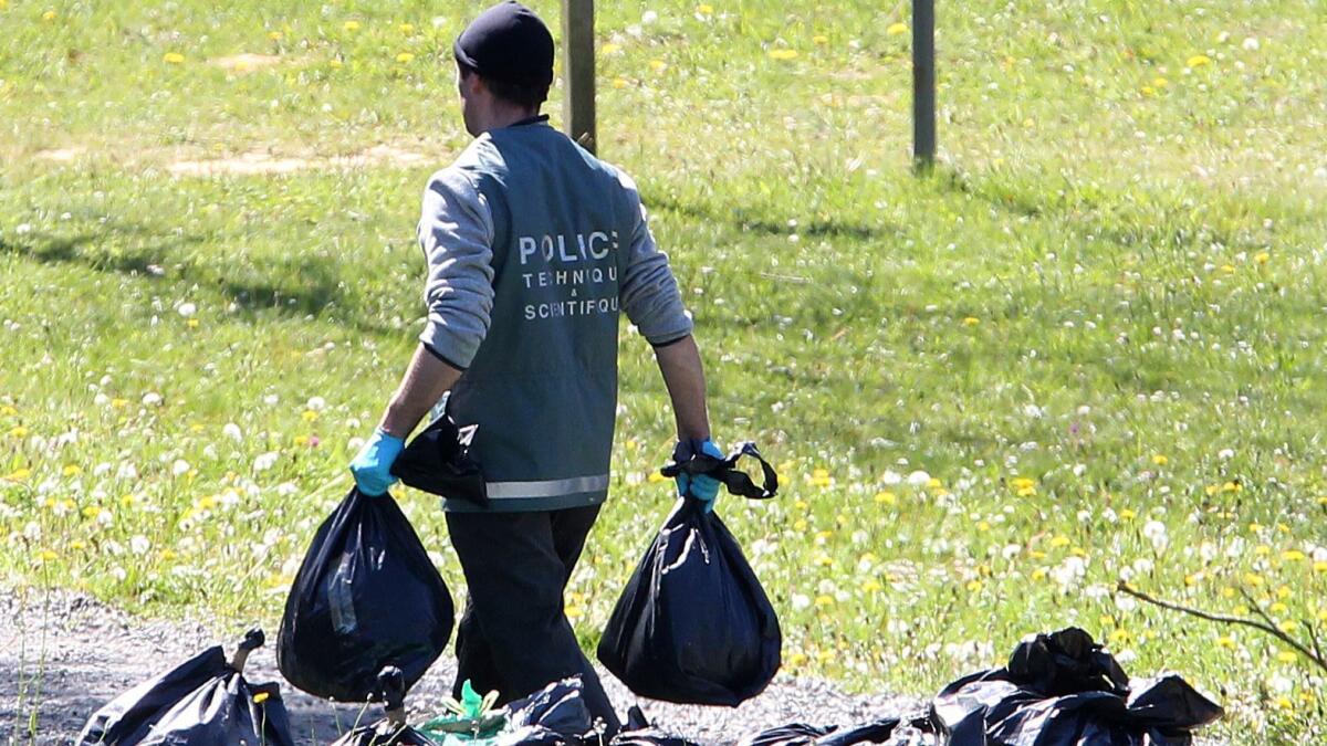 A police officer collects items at a hideout used by Basque separatist guerrillas in Saint-Pee-sur-Nivelle, southwestern France, on Saturday.