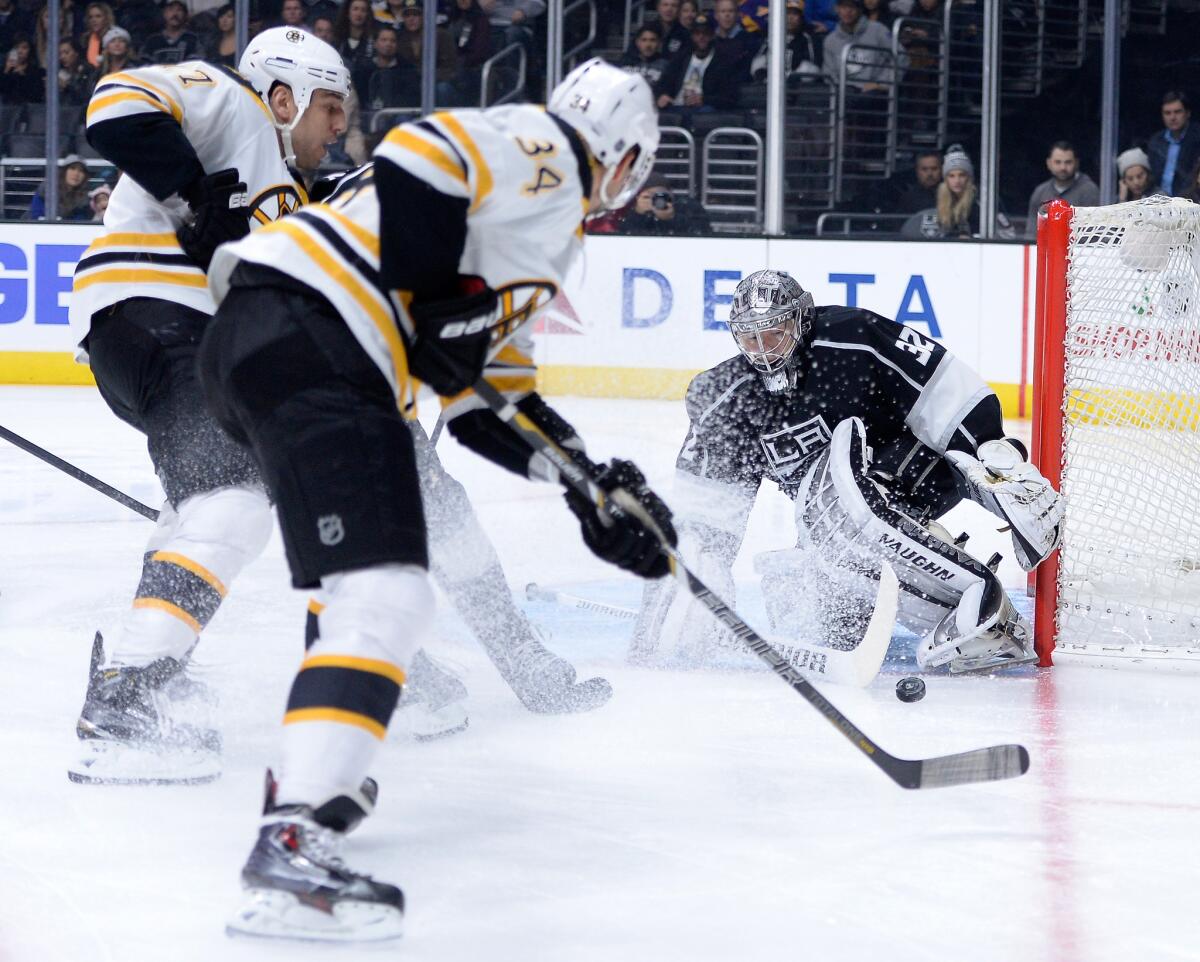 Jonathan Quick makes a save in front of Boston's Milan Lucic, left, and Carl Soderberg on Tuesday night at Staples Center.