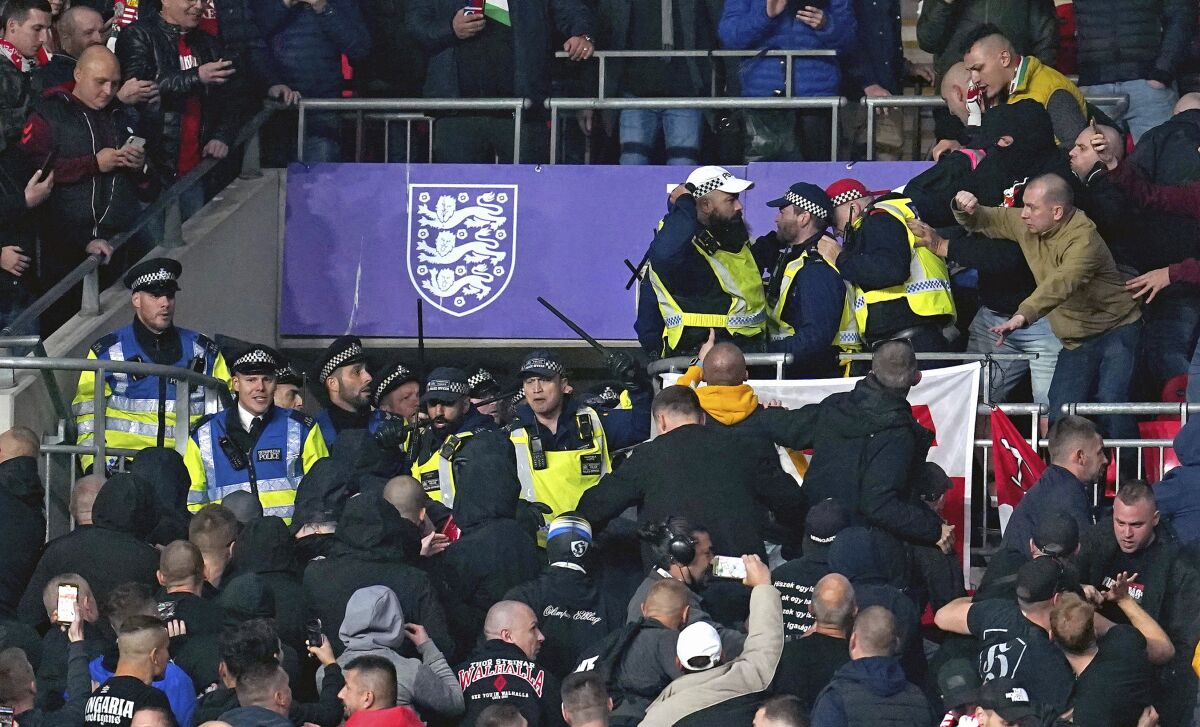 Hungary fans clash with police officers in the stands during the World Cup group I Qualifying soccer match between England and Hungary at Wembley Stadium, London, Tuesday, Oct. 12, 2021. Hungary supporters have clashed with police during the start of a World Cup qualifier against England at Wembley Stadium. Disorder by Hungary fans — including racism — during the home match against England in Budapest last month led to Hungary having to play Saturday's game against Albania in an empty stadium. (Nick Potts/PA via AP)