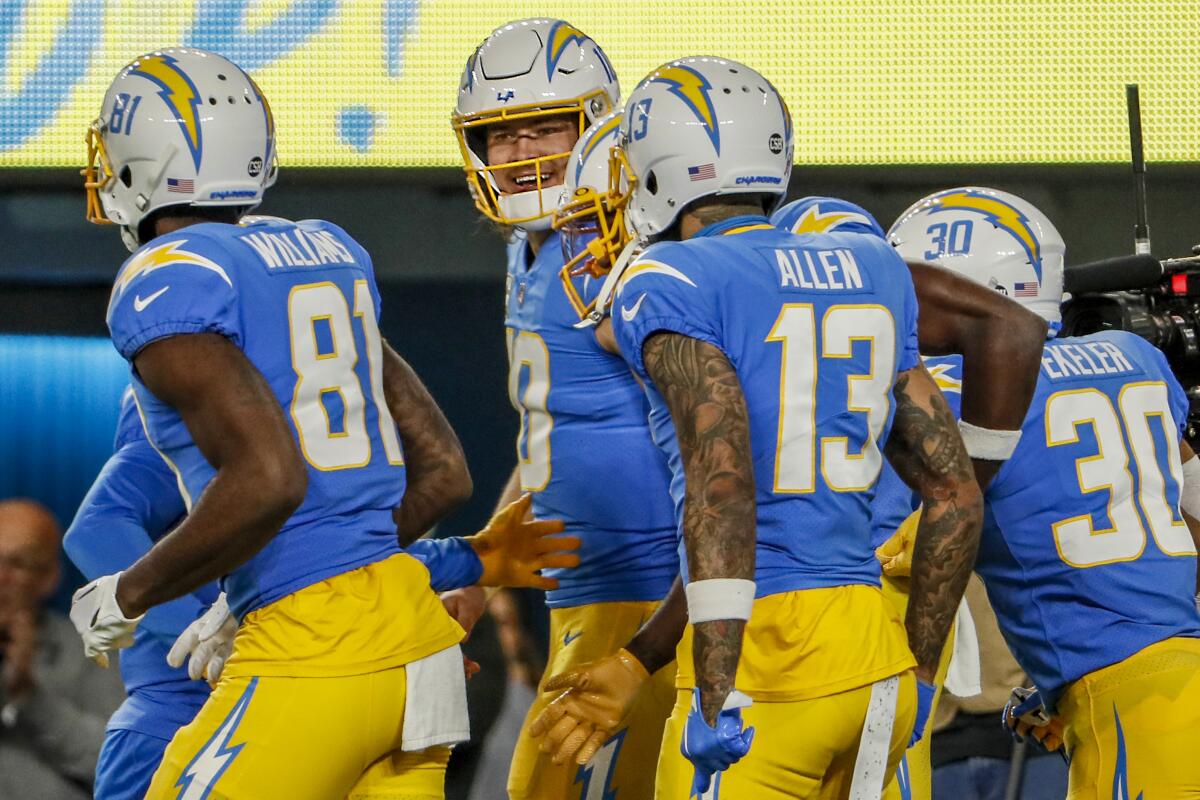 Justin Herbert (10) celebrates with Chargers teammates Mike Williams (81), Keenan Allen (13) and Austin Ekeler (30).