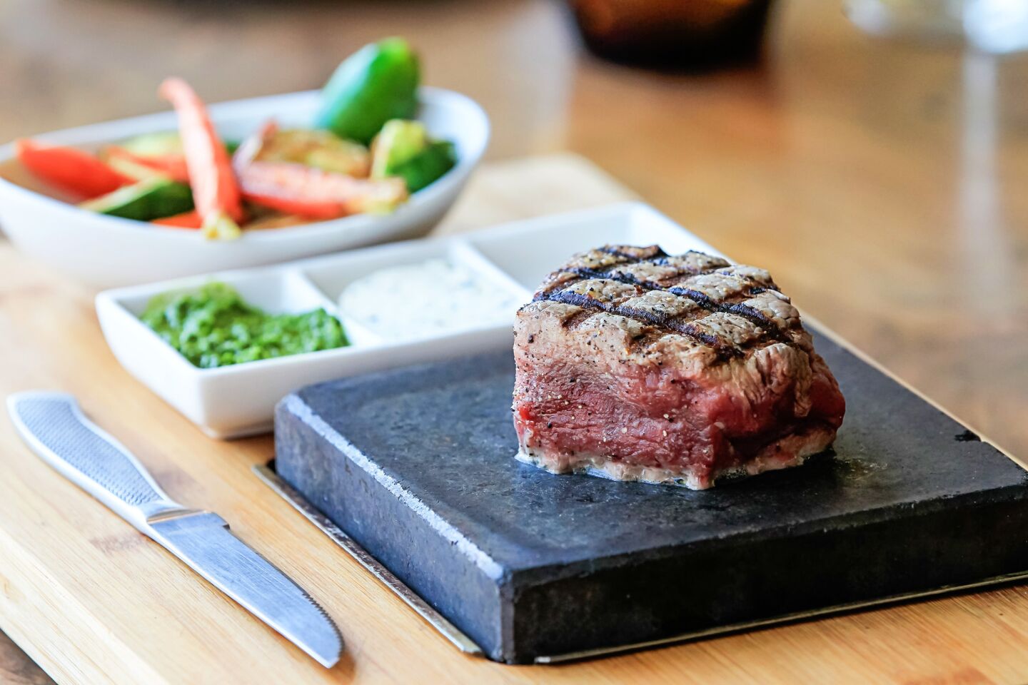 Right at the bottom of the dinner menu, there’s an 8-ounce aged Angus filet mignon. It’s served rare on a hot stone from Australia. Heated to 450 degrees — there’s a special oven to get the stone to that high temperature — the stone allows the diner to cook the steak to his or her liking.