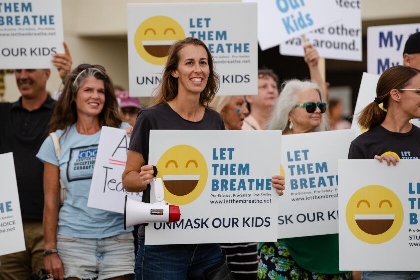 Sharon McKeeman, founder of Let Them Breathe, holds a sign protesting against the state mask mandate in schools in front of the Vista Unified School District on Thursday, July 22, 2021.