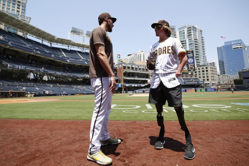 San Diego, CA - JULY 11: San Diego Padres' pitcher Joe Musgrove talks with Landis Sims before the a game against the Colorado Rockies at Petco Park on Sunday, July 11, 2021 in San Diego, CA. Sims is an athlete with the Challenged Athletes Foundation who Musgrove has helped out. (K.C. Alfred / The San Diego Union-Tribune)