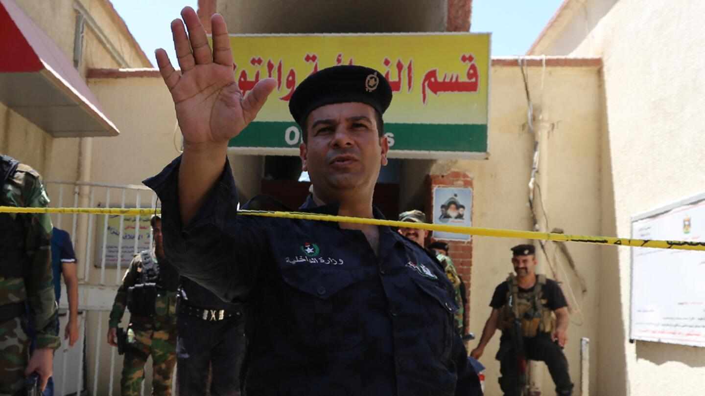 An Iraqi security officer gestures outside Yarmuk hospital in west Baghdad on August 10, 2016, after an overnight fire tore through the maternity ward, killing at least 11 premature babies, medical and security sources said.