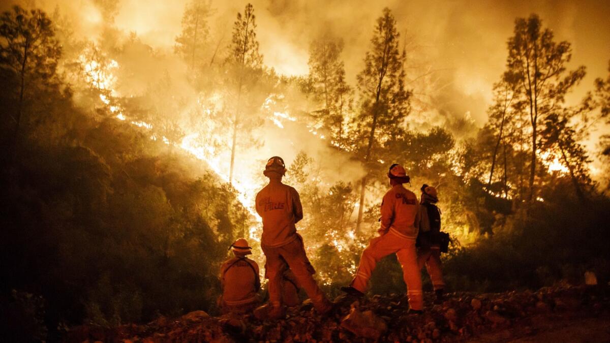 Firefighters monitor a burn operation on top of a ridge near the town of Ladoga, Calif., on Aug. 7.