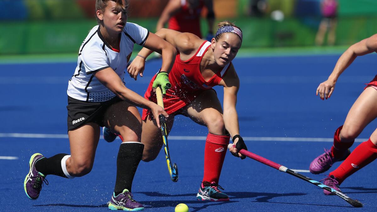 American Alyssa Manley pressures Germany's Lisa Altenburg during a quarterfinal women's field hockey game Monday.