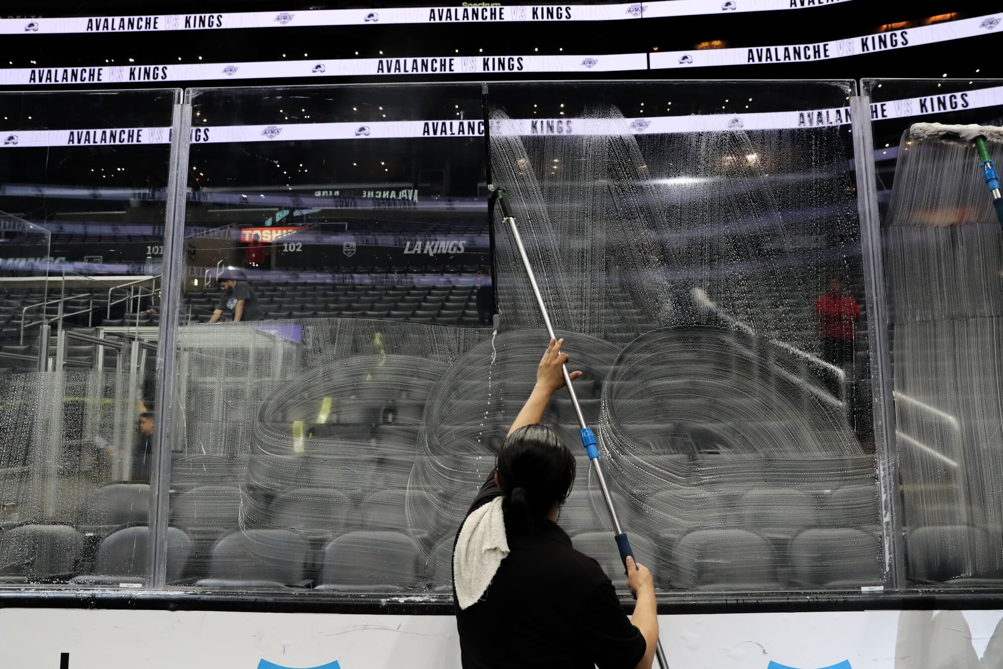 Un employé de Crypto.com Arena lave des panneaux de plexiglas 