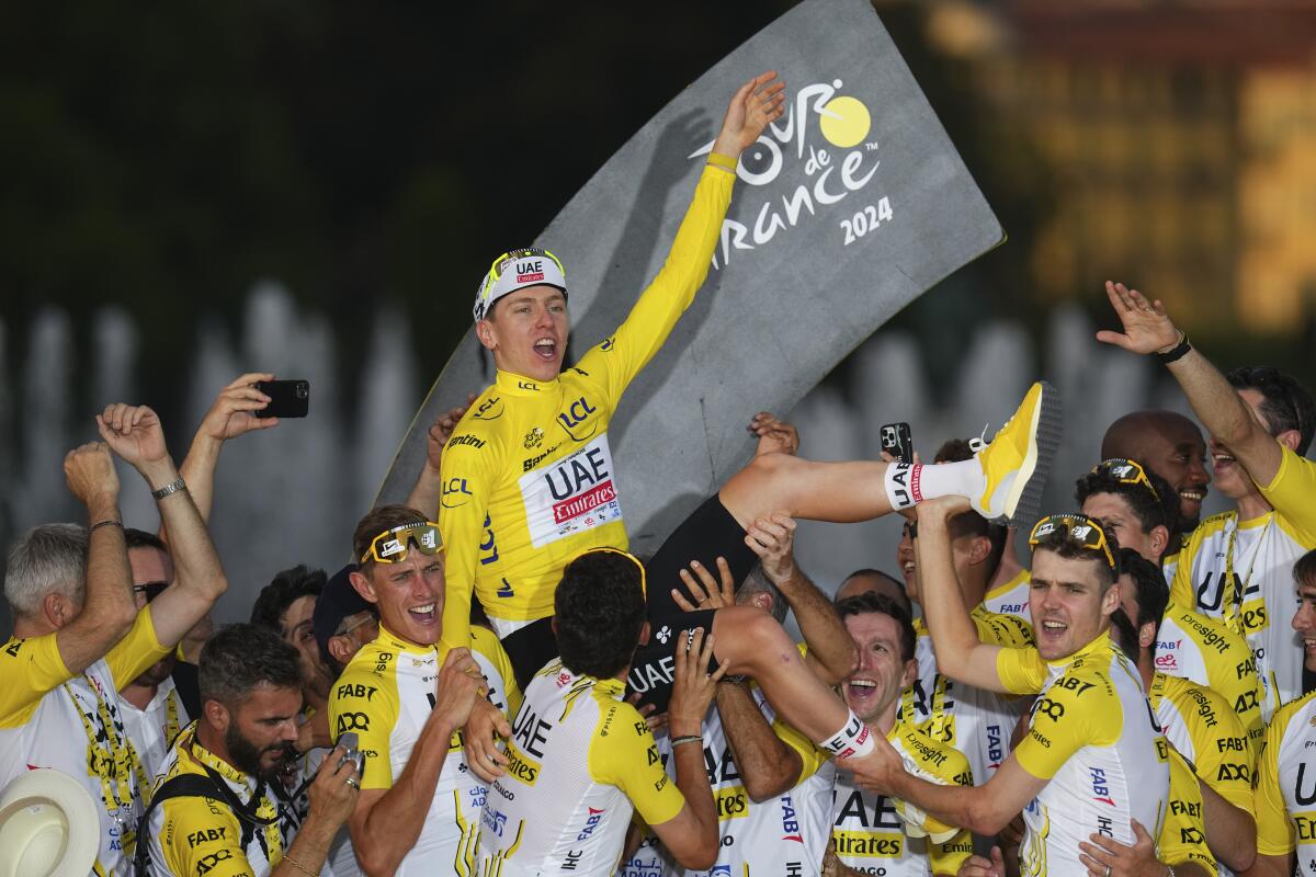 Tour de France winner Tadej Pogacar celebrates with his team on Sunday.