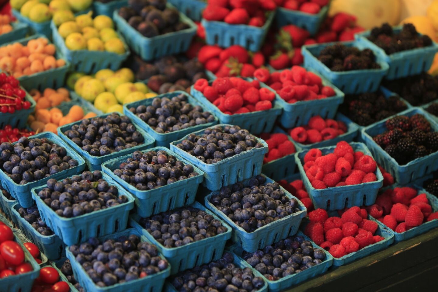 Fruits of varying shades brighten a produce stand.