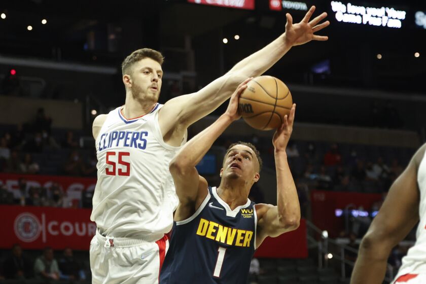 Denver Nuggets forward Michael Porter Jr. (1) goes up to basket under pressure from Los Angeles Clippers Center Isaiah Hartenstein (55) during the first half of a preseason NBA basketball game, Monday, Oct. 4, 2021, in Los Angeles. (AP Photo/Ringo H.W. Chiu)
