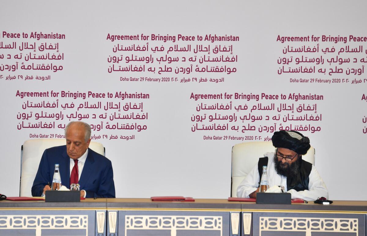 U.S. Special Representative Zalmay Khalilzad, left, and Taliban political leader Abdul Ghani Baradar sign a peace agreement in Doha, Qatar on Feb. 29, 2019.