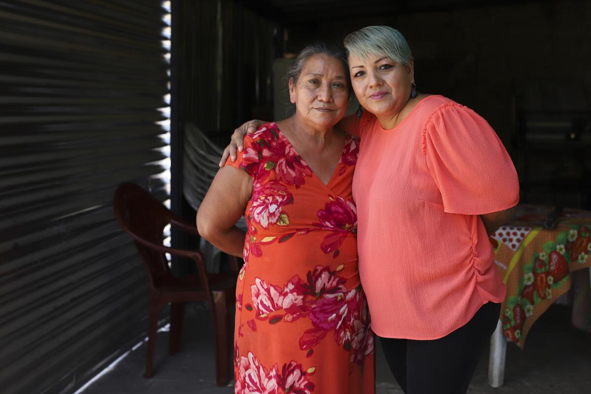 Iris Franco, right, hugs her mother, Elsa Victorina Franco, at her home, in El Ranchador, Santa Ana, El Salvador, Friday, March 5, 2021. The Salvadoran family lives humbly but is in a better place thanks to financial support from a family member in the United States who is part of the Temporary Protected Status program. (AP Photo/Salvador Melendez)