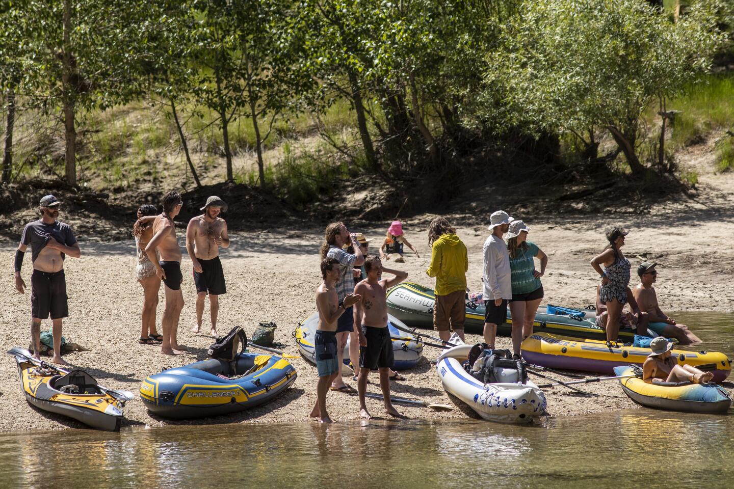 Park visitors along the Merced River.