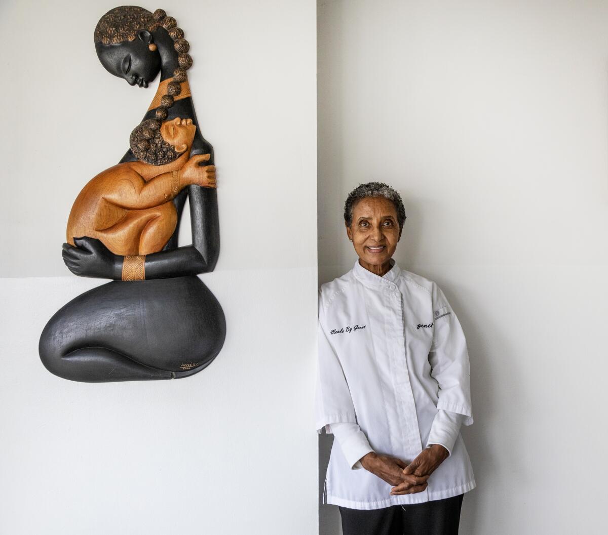 Genet Agonafer next to a sculpture of Mary and baby Jesus made by Ethiopian artist Bereket Mamo.