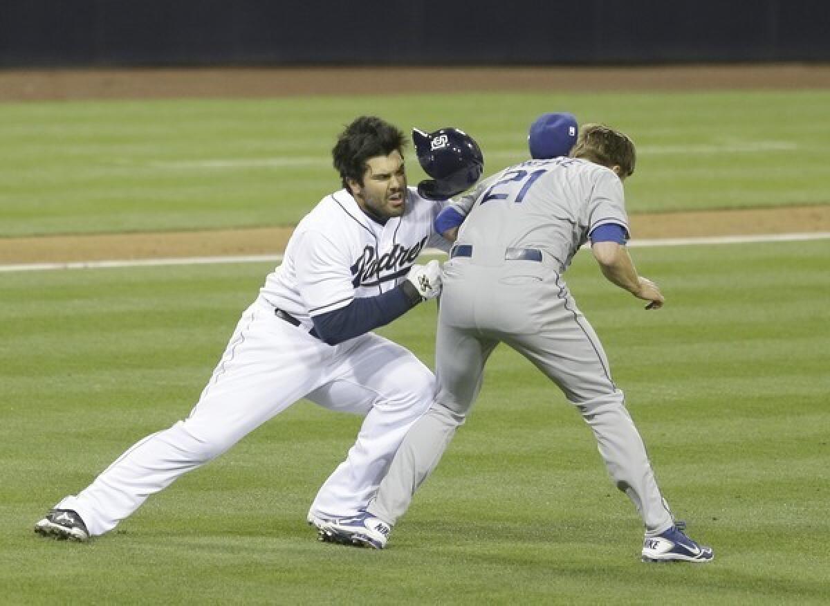 San Diego Padres' Carlos Quentin charges into Los Angeles Dodgers pitcher Zack Greinke after being hit by a pitch in the sixth inning of baseball game in San Diego.