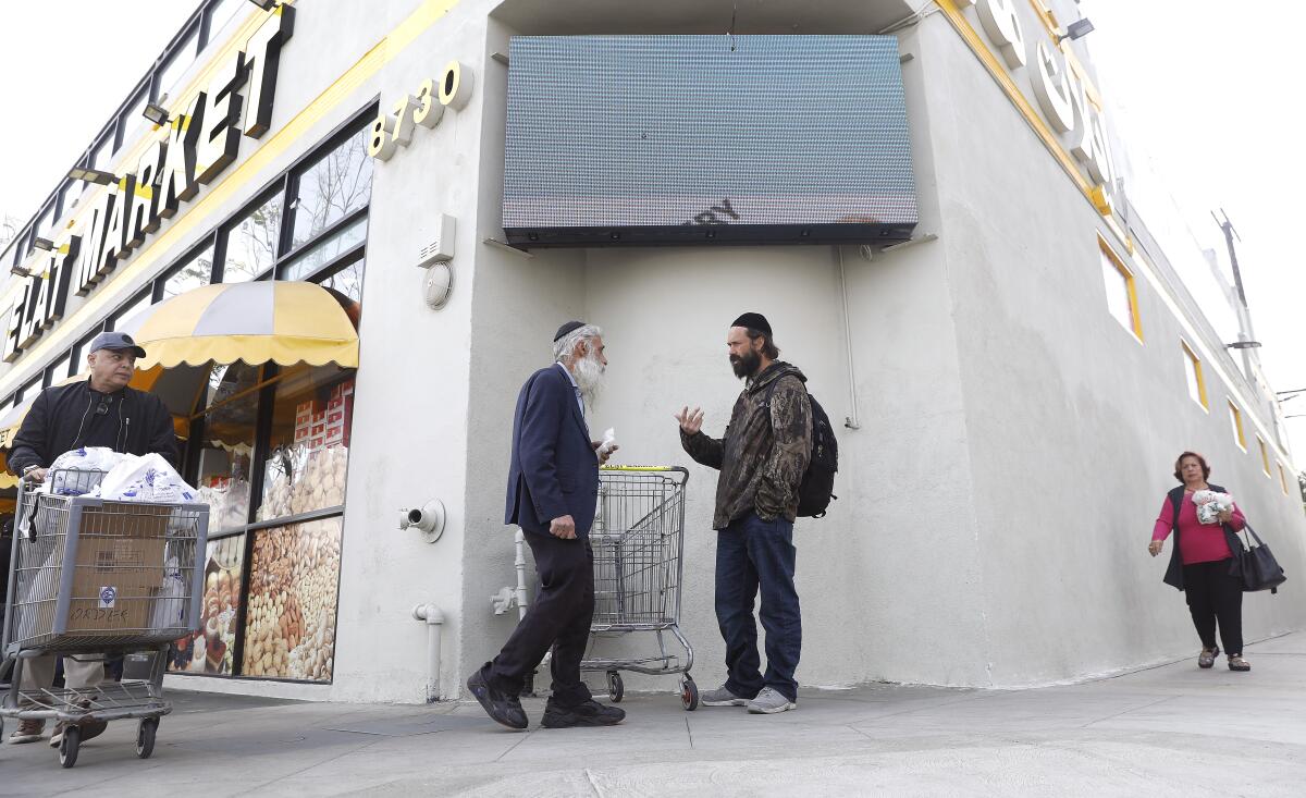 People pass by Elat Market along Pico Boulevard in the Pico-Robertson area of Los Angeles.
