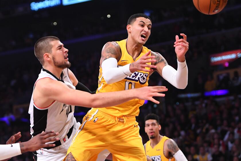 Clippers center Ivica Zubac battles Lakers forward Kyle Kuzma for the ball under the basket during the first half of a game Dec. 25, 2019.