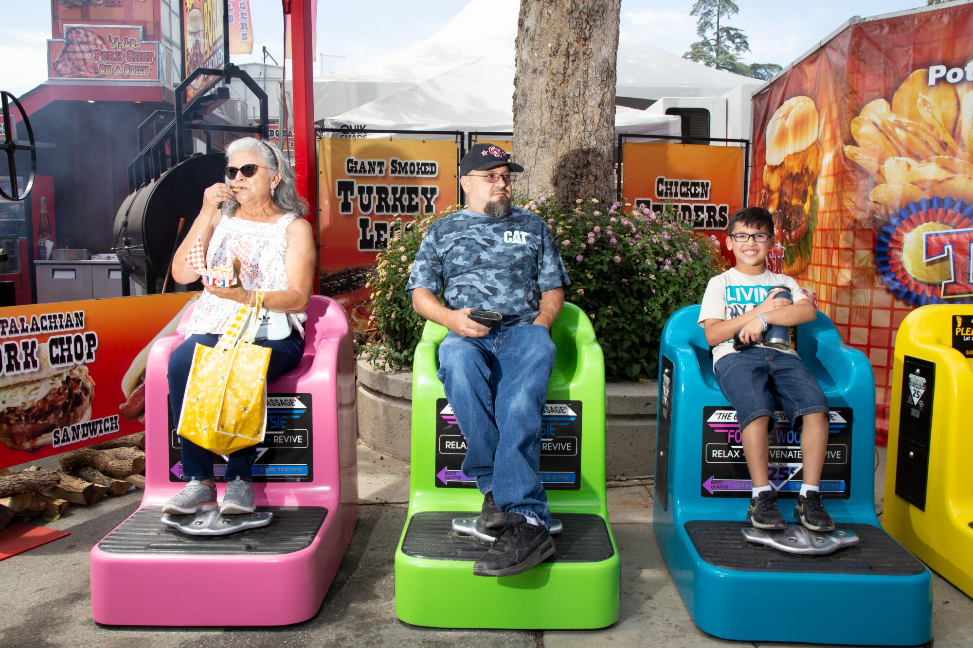 Three fairgoers get their feet massaged.