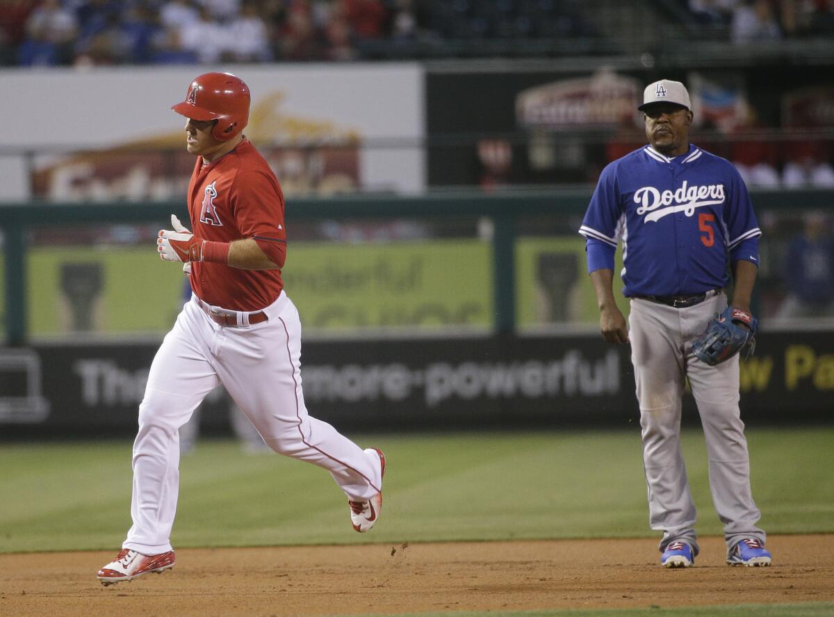 Dodgers third baseman Juan Uribe watches Angels outfielder Mike Trout round the bases after hitting a home run in a Freeway Series preseason exhibition.