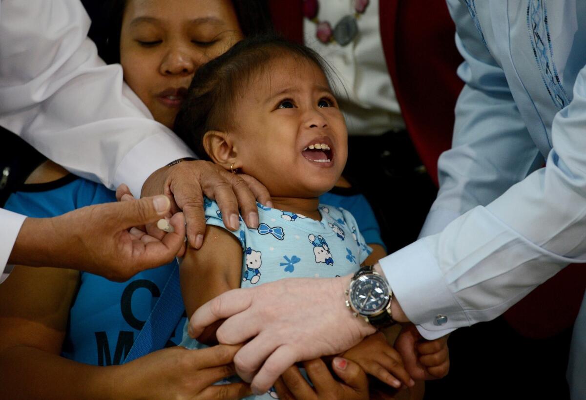 A girl in the Philippine capital of Manila is vaccinated against measles on Friday. The country is experiencing a large outbreak of the disease. Fifteen Californians have come down with measles thus far this year, officials said.