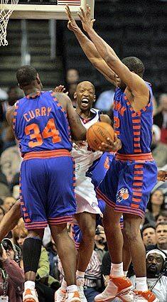 Clipper Sam Cassell is squeezed by Eddy Curry and Antonio Davis of the New York Knicks.