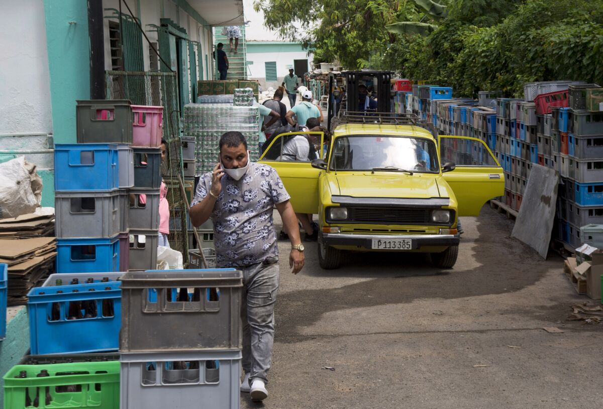 Customers enter through the back of Mercabal wholesale market, to load their merchandise in Havana, Cuba, Thursday, July 30, 2020. The government is letting private businesses buy wholesale for the first time. (AP Photo/Ismael Francisco)