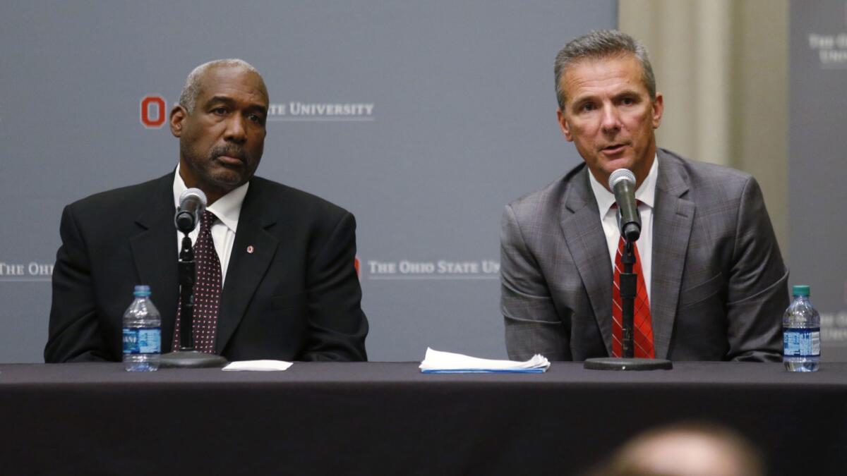 Ohio State football coach Urban Meyer, right, answers questions as athletic director Gene Smith listens during a news conference in Columbus, Ohio.
