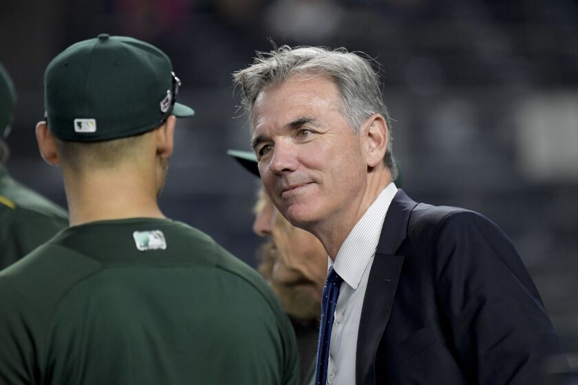 Oakland Athletics minority owner and executive vice president Billy Beane, right, talks with players before the American League wildcard playoff baseball game against the New York Yankees, Wednesday, Oct. 3, 2018, in new York (AP Photo/Bill Kostroun)