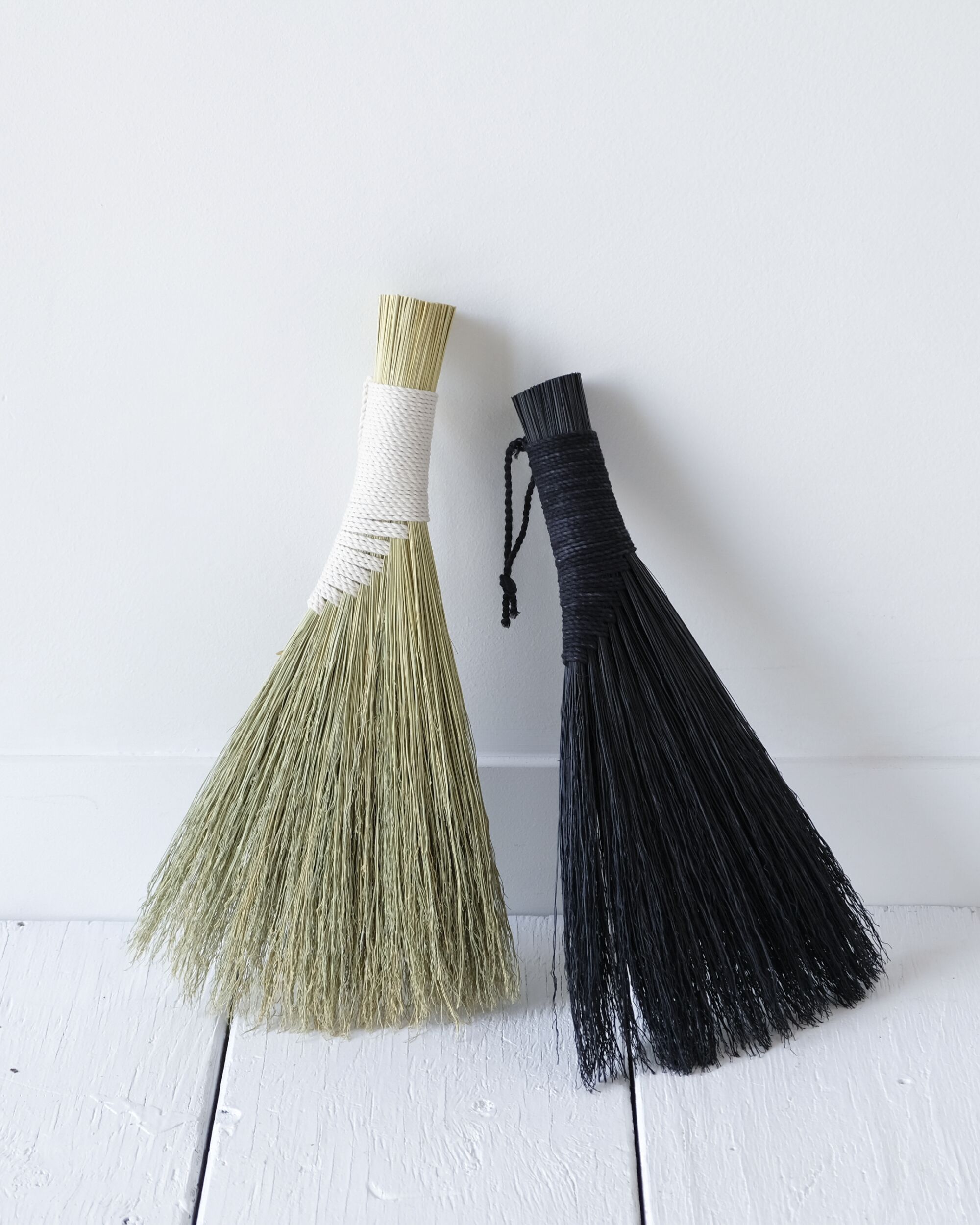 Winged hand brooms in tan and black