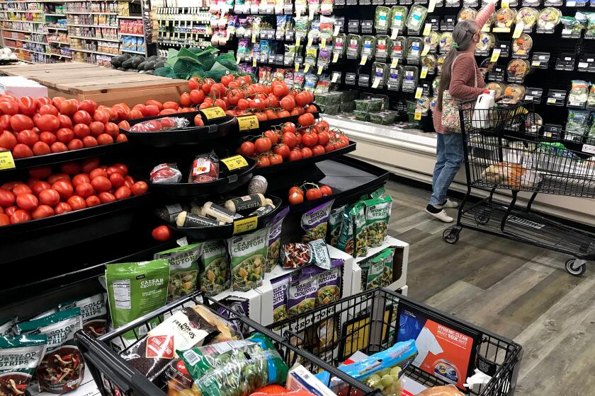 LONG BEACH, CALIF. - DEC. 16, 2020. A shoppers chooses fresh produce in the Von's grocery store iin Long Beach on Wednesday, Dec. 16, 2020. (Luis Sinco/Los Angeles Times)